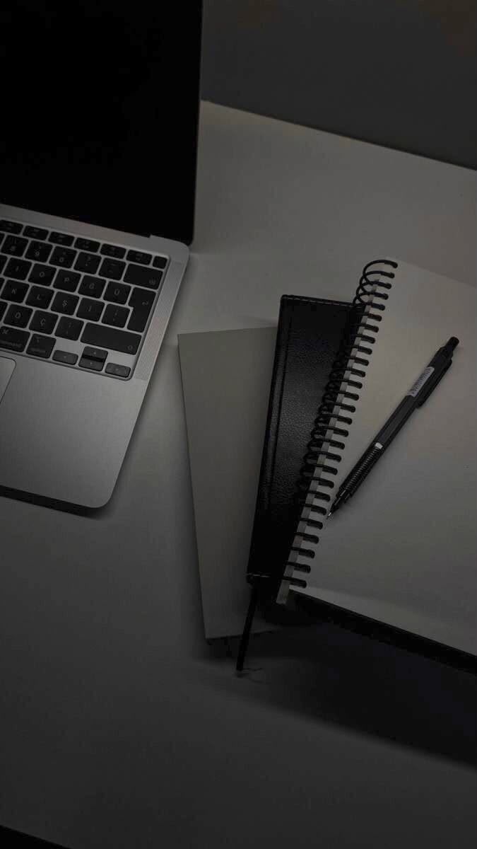 Laptop y cuadernos de trabajo en escritorio editorial